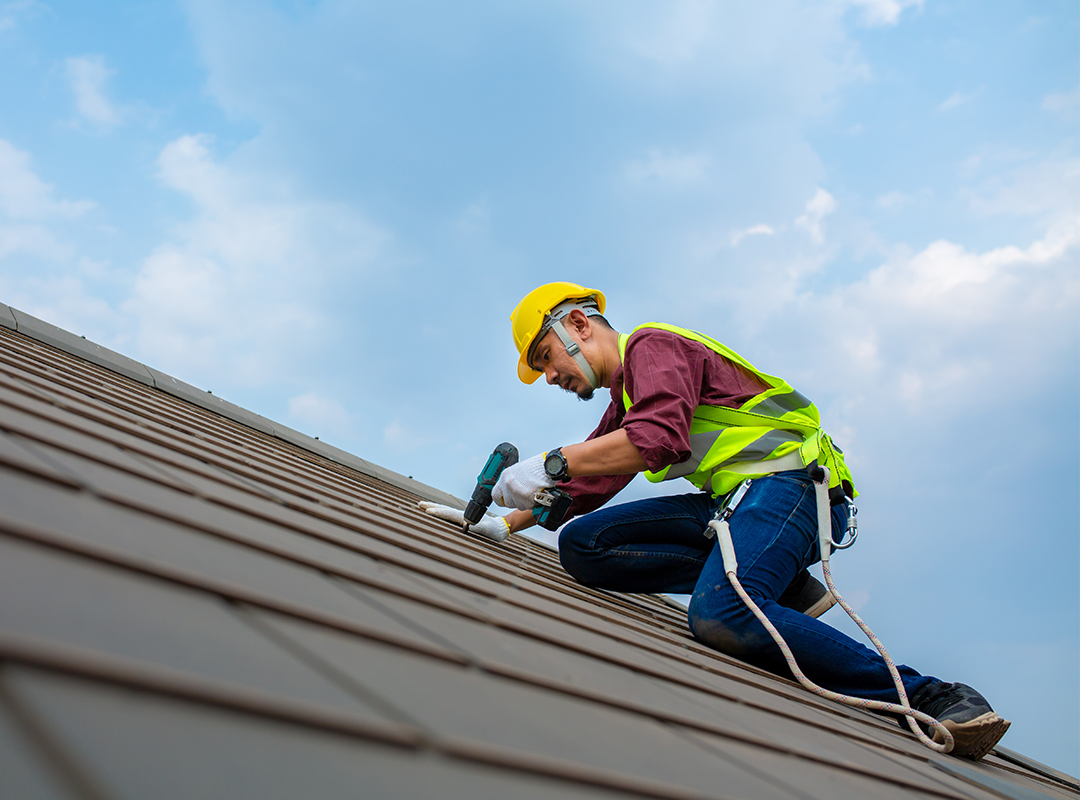 Roofing contractor working on metal roof